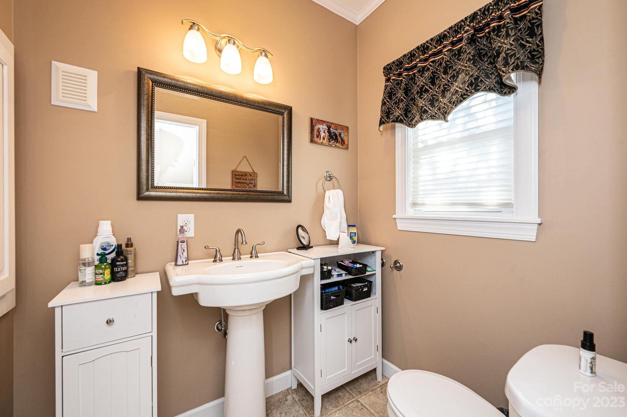 209 Catawba Avenue Hickory, NC 28601 - Photo 14 of 28 a bathroom with a toilet sink and mirror