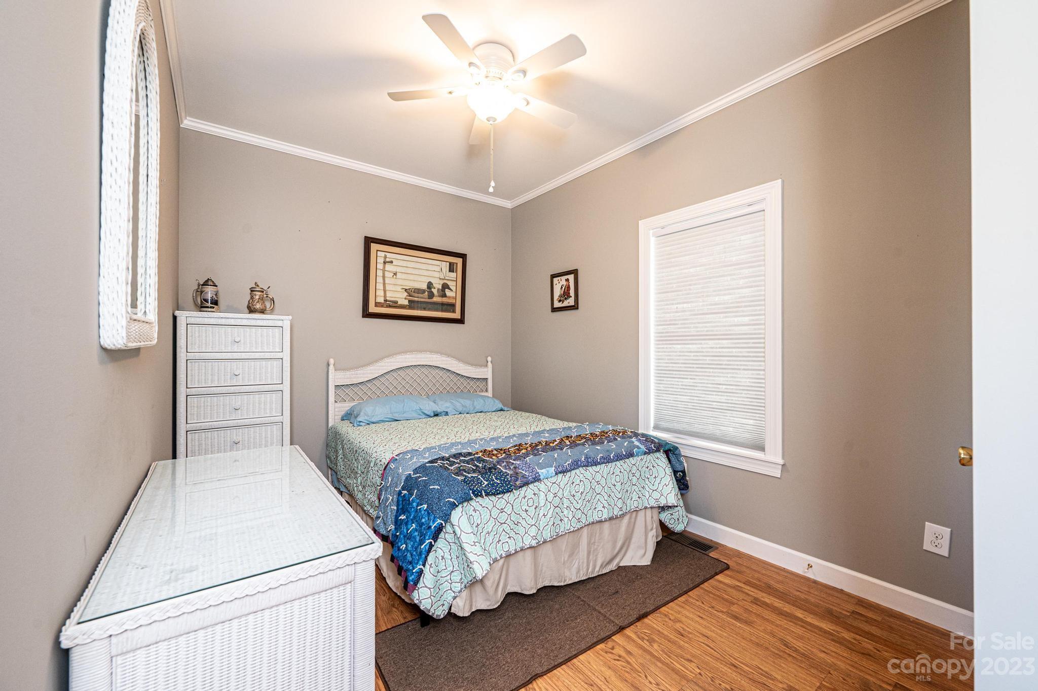209 Catawba Avenue Hickory, NC 28601 - Photo 16 of 28 a bedroom with a large bed and a chandelier
