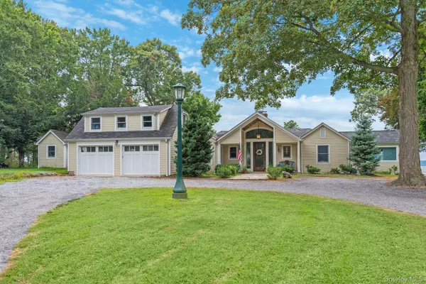 a front view of a house with a yard and trees