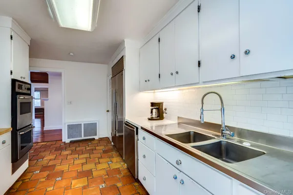 a kitchen with kitchen island granite countertop a sink a counter space and cabinets