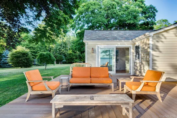 a view of a patio with table and chairs and a barbeque with wooden fence