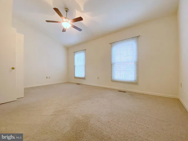 an empty room with closet and ceiling fan