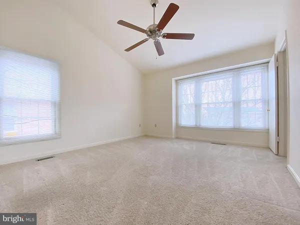 an empty room with a ceiling fan and a window