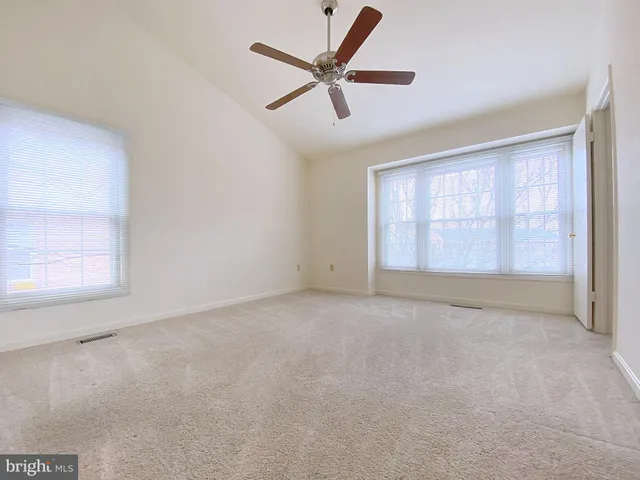 an empty room with a ceiling fan and a window