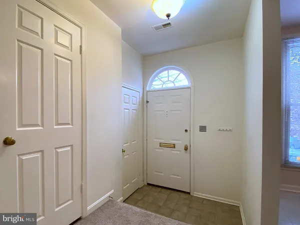 an empty room with closet and a chandelier fan