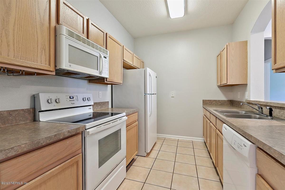10550 Baymeadows Road, Unit 607 Jacksonville, FL 32256 - Photo 4 of 15 a kitchen with stainless steel appliances granite countertop a stove a sink and a microwave