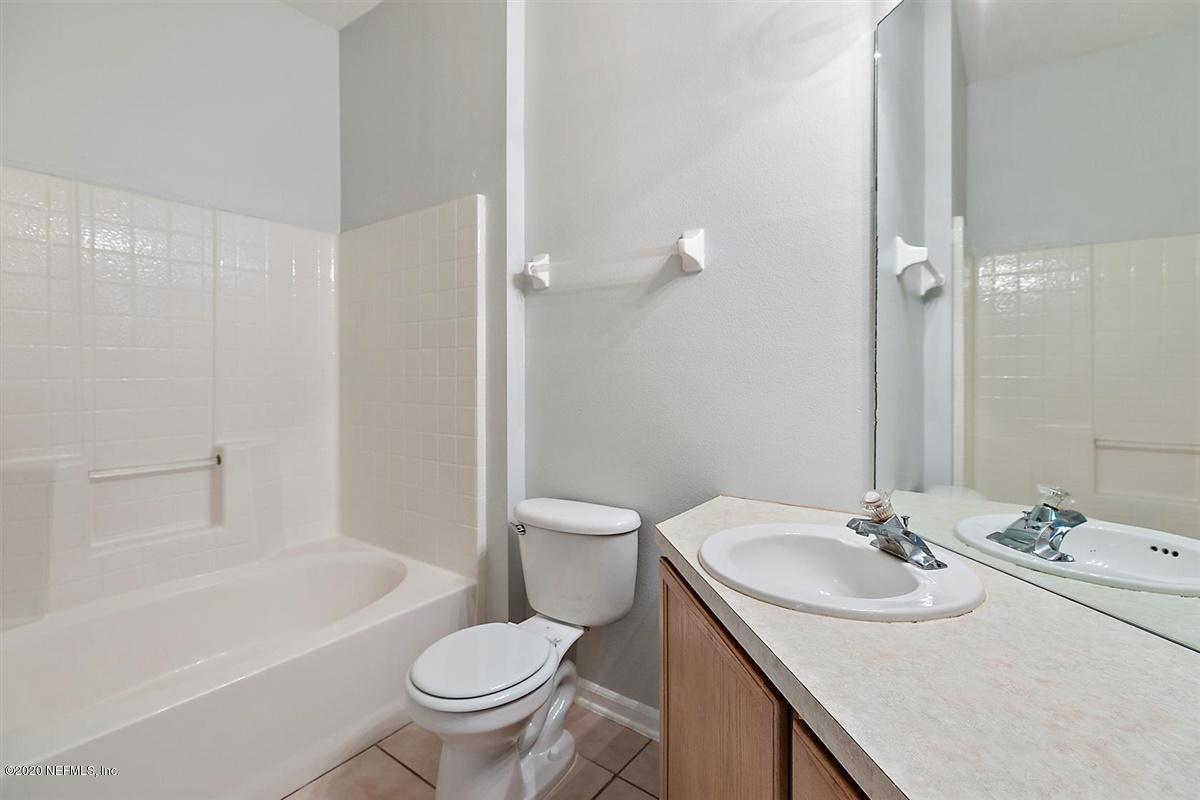 10550 Baymeadows Road, Unit 607 Jacksonville, FL 32256 - Photo 6 of 15 a bathroom with a granite countertop sink a toilet a mirror and a tub