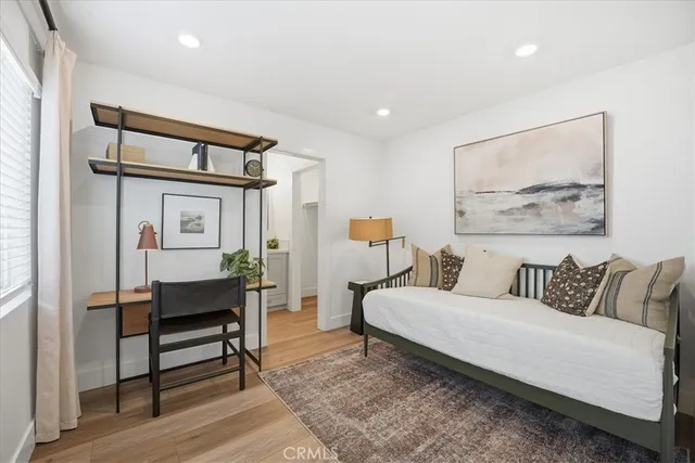 a spacious bedroom with a bed a table and painting on the wall