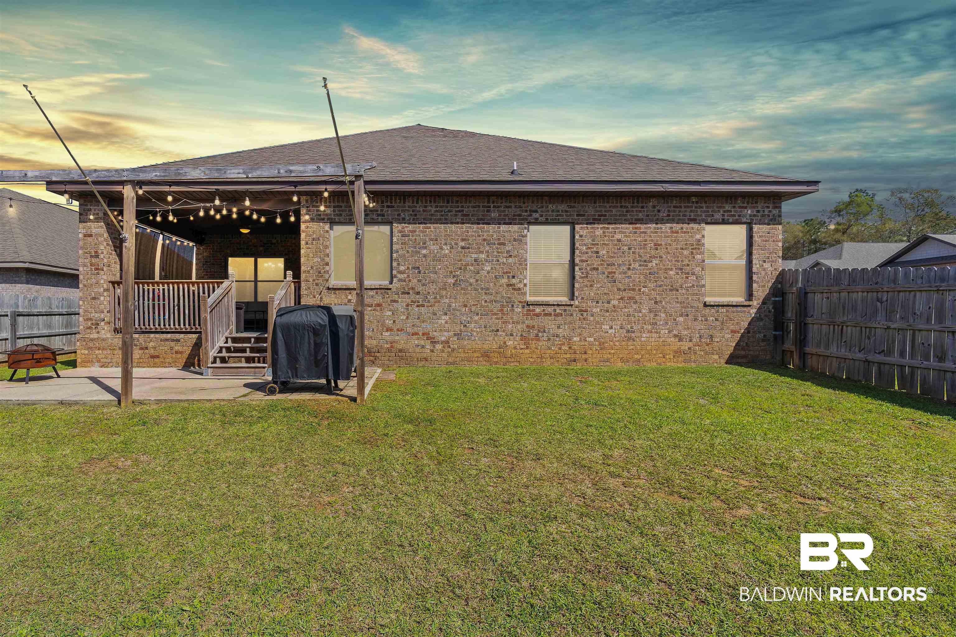 11712 Alameda Court Spanish Fort, AL 36527 - Photo 26 of 27 Back house at dusk with a patio and a lawn