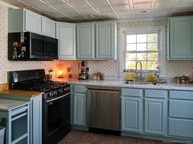 a kitchen with stainless steel appliances a stove microwave and sink