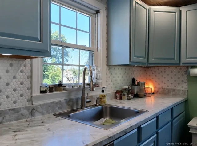 a kitchen with stainless steel appliances granite countertop a sink a refrigerator and a window