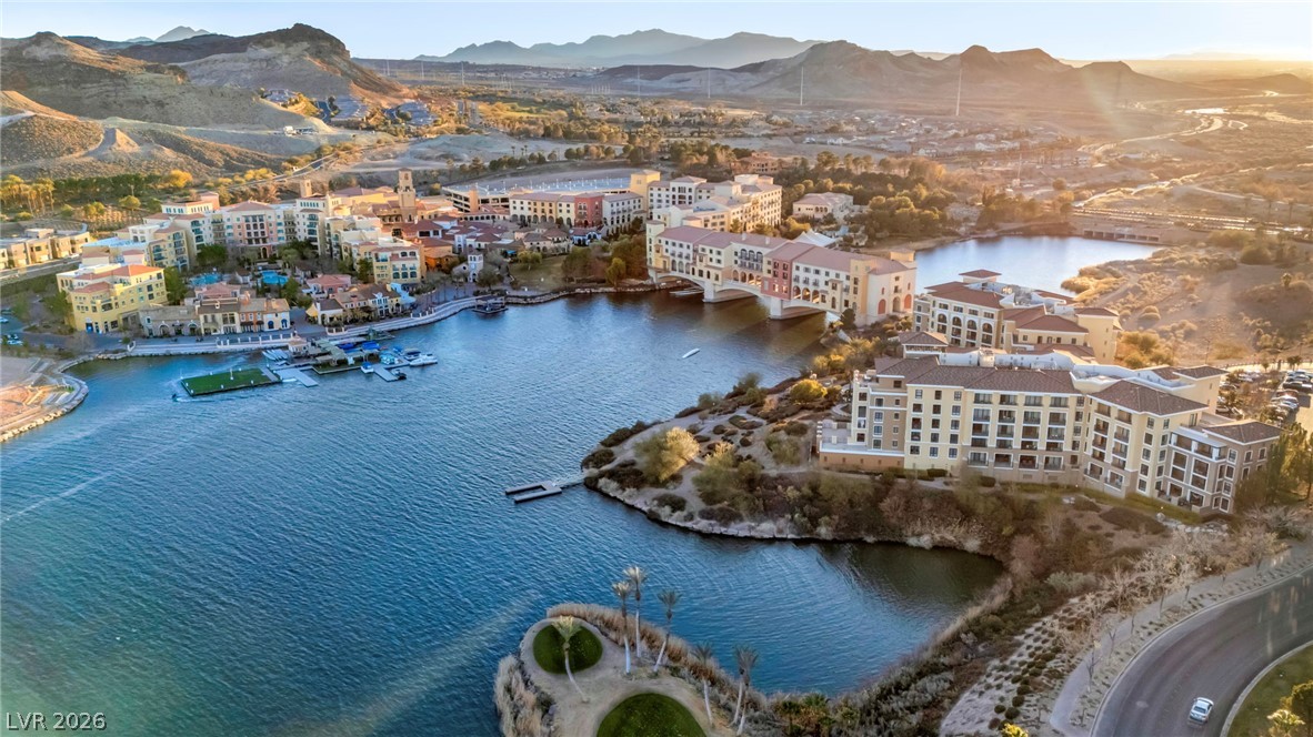 3 Rue Promenade Way Henderson, NV 89011 - Photo 16 of 26 A picturesque waterfront community unfolds with Mediterranean-inspired architecture, set against a dramatic mountainous backdrop.