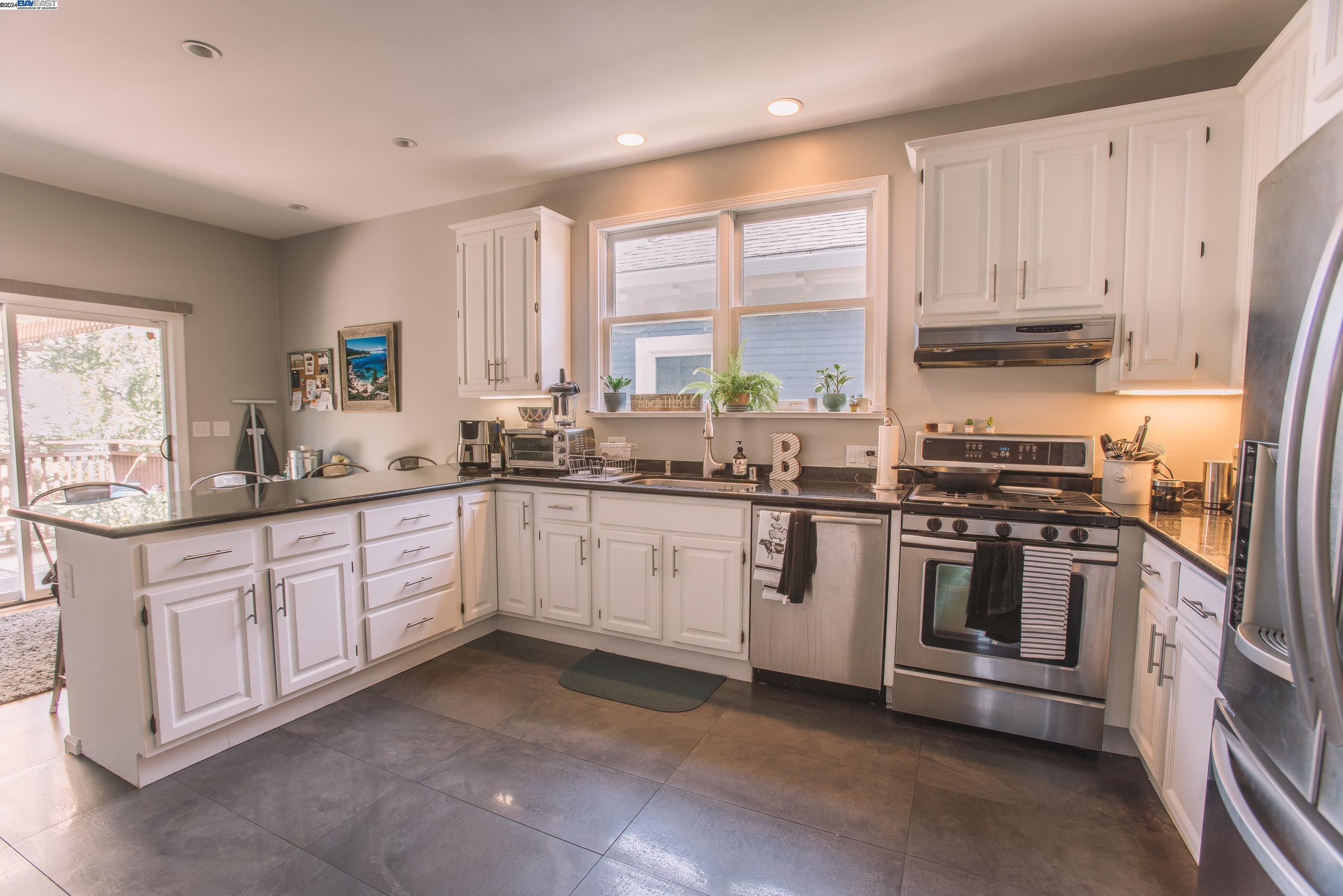 4113 Gilbert Street Oakland, CA 94611 - Photo 4 of 22 a kitchen with granite countertop white cabinets and stainless steel appliances