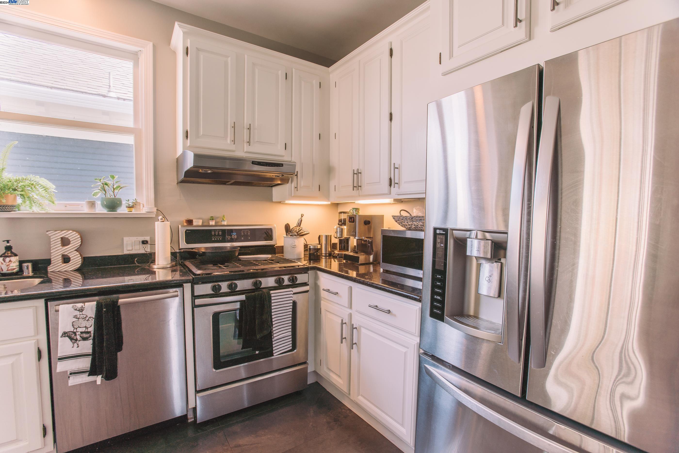 4113 Gilbert Street Oakland, CA 94611 - Photo 5 of 22 a kitchen with stainless steel appliances white cabinets and a refrigerator