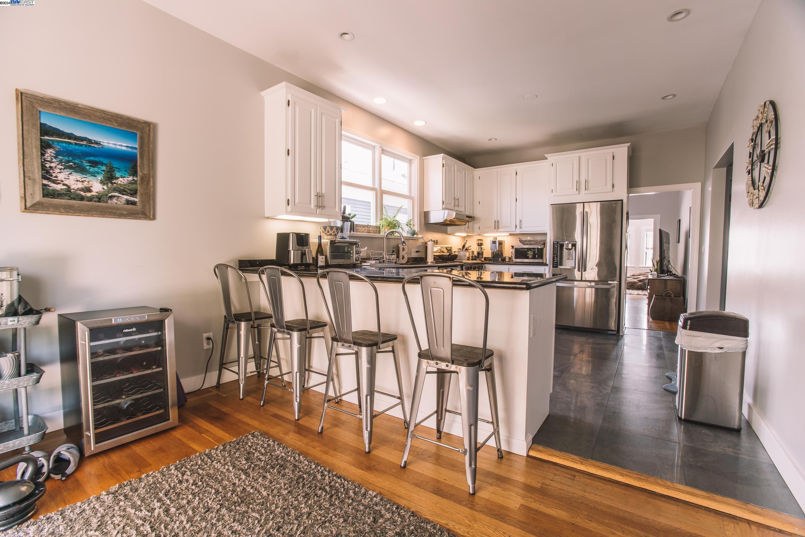4113 Gilbert Street Oakland, CA 94611 - Photo 7 of 22 a kitchen with stainless steel appliances granite countertop a refrigerator dining table and chairs