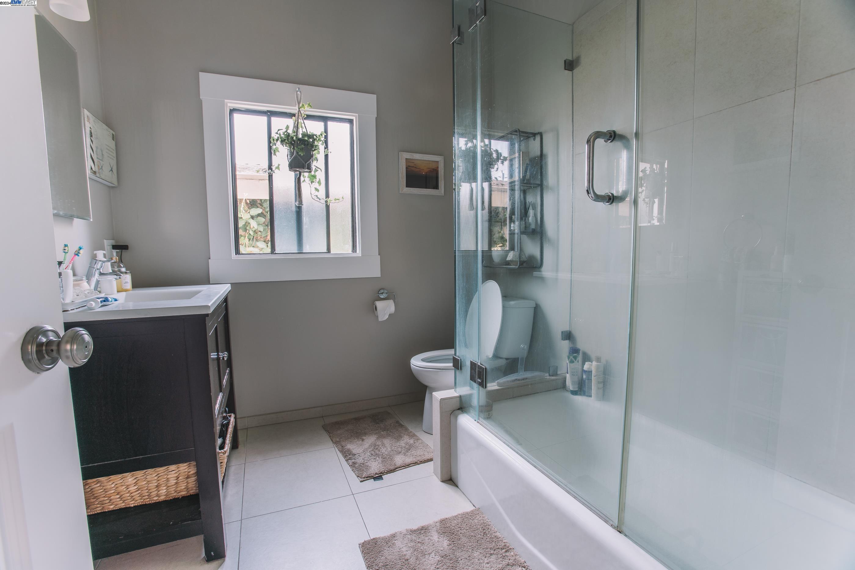 4113 Gilbert Street Oakland, CA 94611 - Photo 10 of 22 a bathroom with a tub a sink a window and a shower