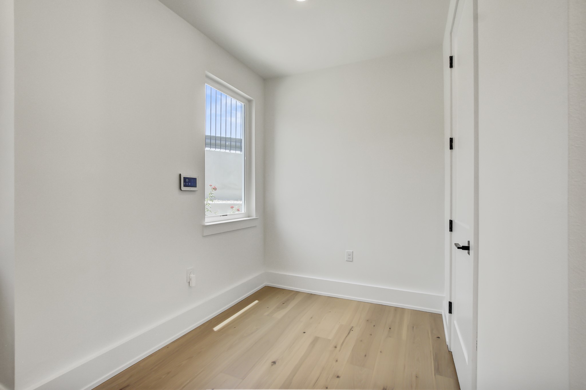 4127 East 12th Street, Unit 8 Austin, TX 78721 - Photo 13 of 32 Spare room featuring light wood-style floors and baseboards