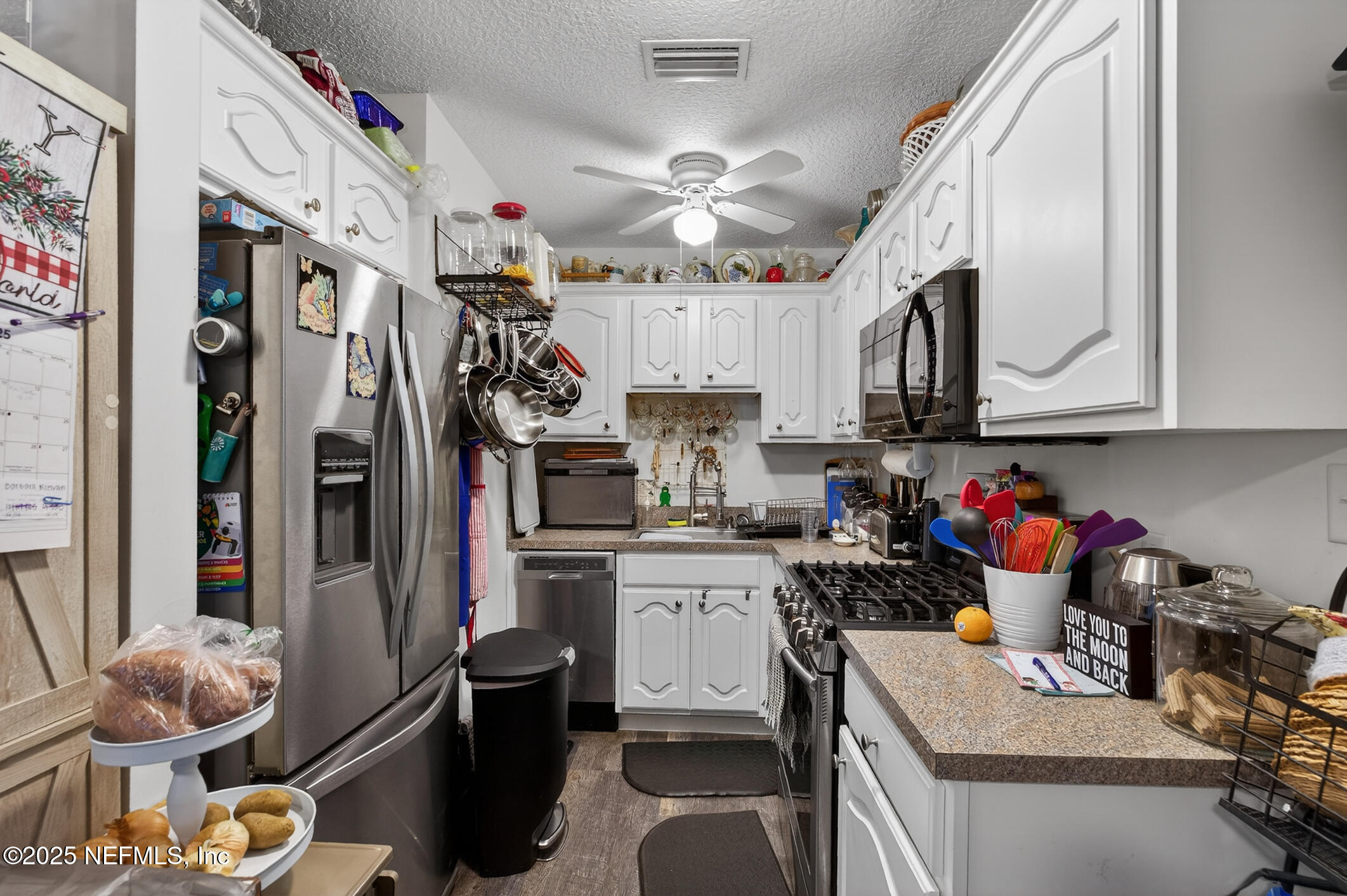 44108 Becker Avenue Callahan, FL 32011 - Photo 20 of 28 a kitchen with stainless steel appliances granite countertop a sink dishwasher and cabinets with wooden floor