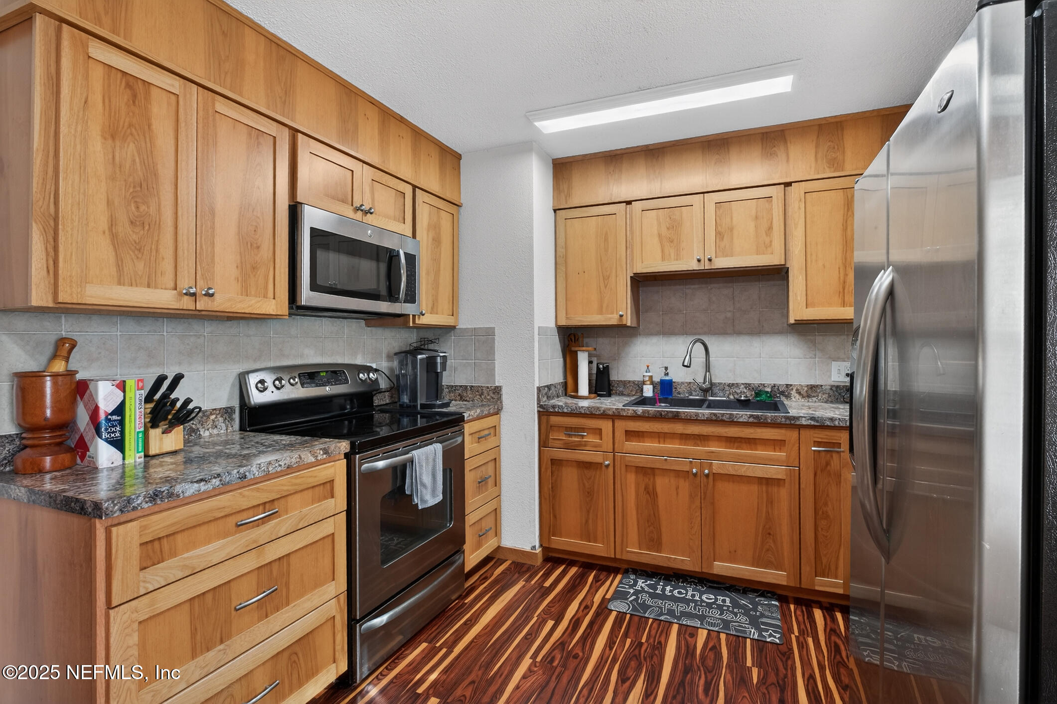 44108 Becker Avenue Callahan, FL 32011 - Photo 6 of 28 a kitchen with stainless steel appliances granite countertop a refrigerator sink and cabinets