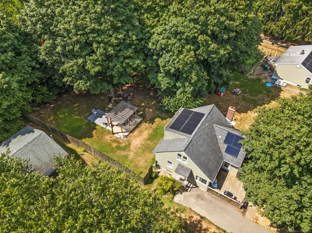 an aerial view of a house with a yard and trees