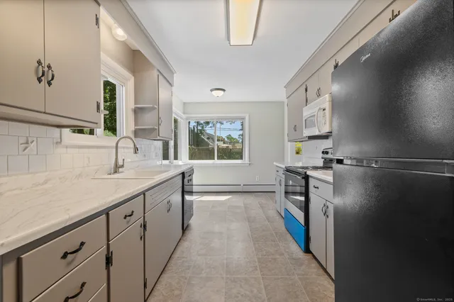 a kitchen with a sink a refrigerator and a window