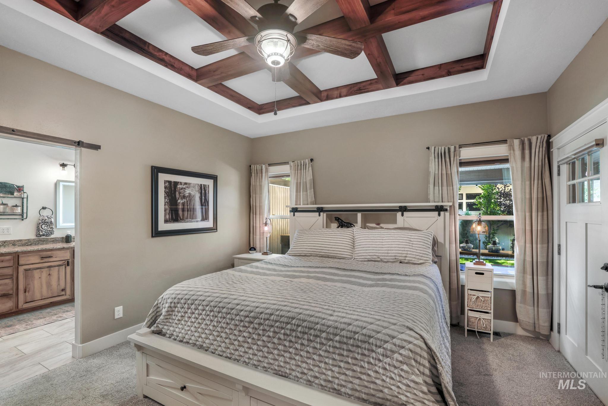 2043 Prospector Way Twin Falls, ID 83301 - Photo 16 of 29 Bedroom featuring coffered ceiling, multiple windows, beamed ceiling, light carpet, and a barn door