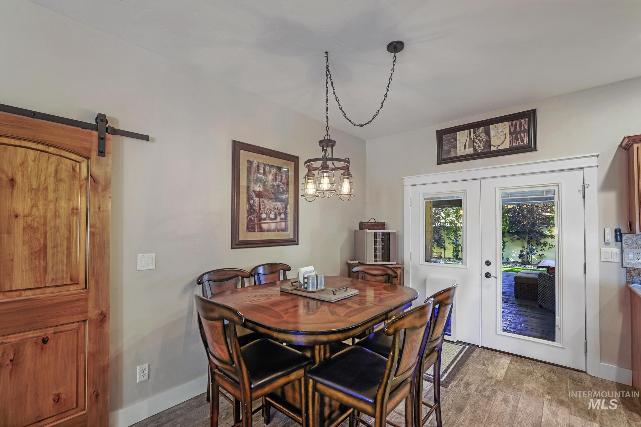 2043 Prospector Way Twin Falls, ID 83301 - Photo 10 of 29 Dining space with a barn door, wood finished floors, a chandelier, and french doors