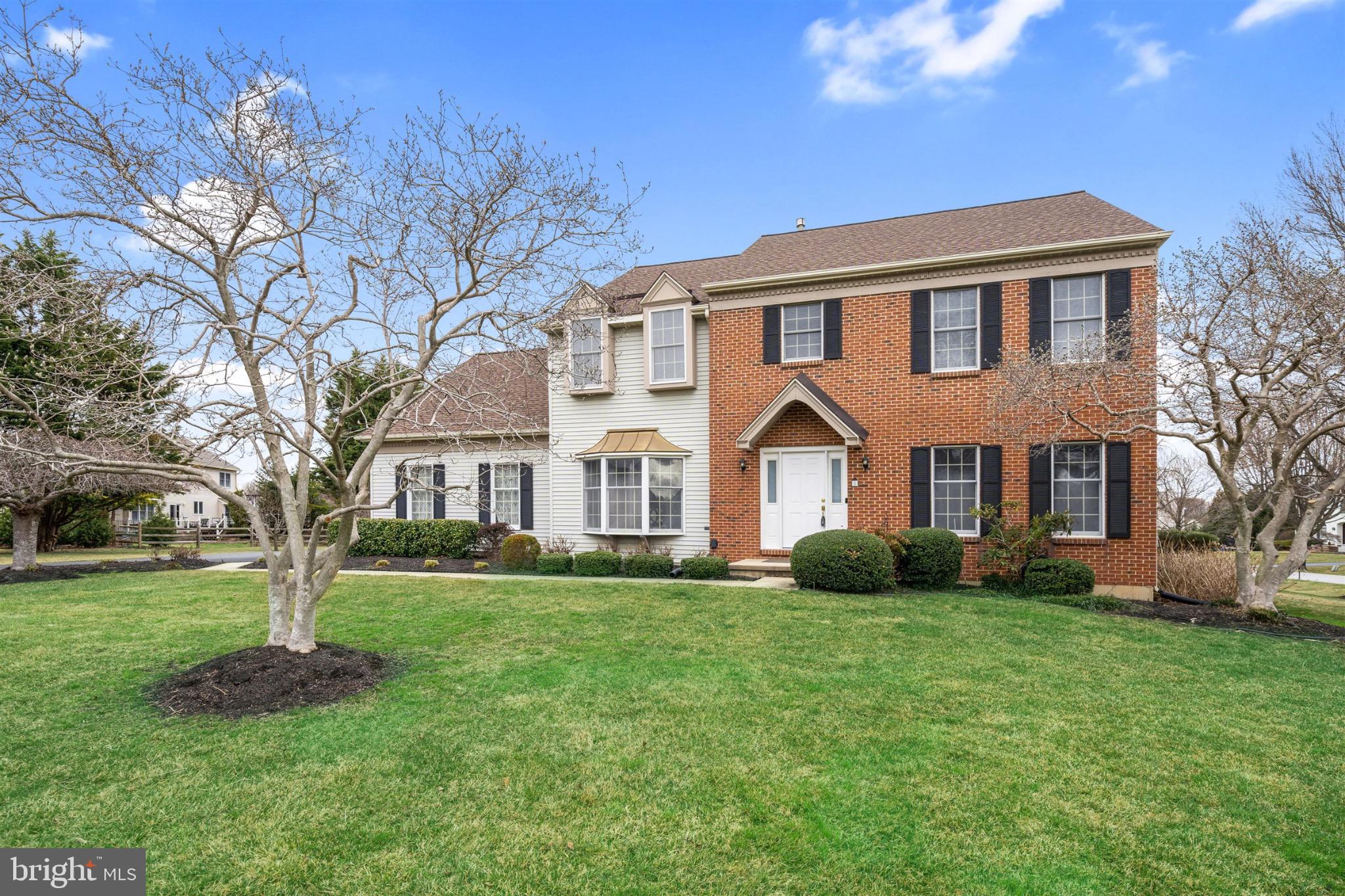 Charming brick home with lush green lawn.