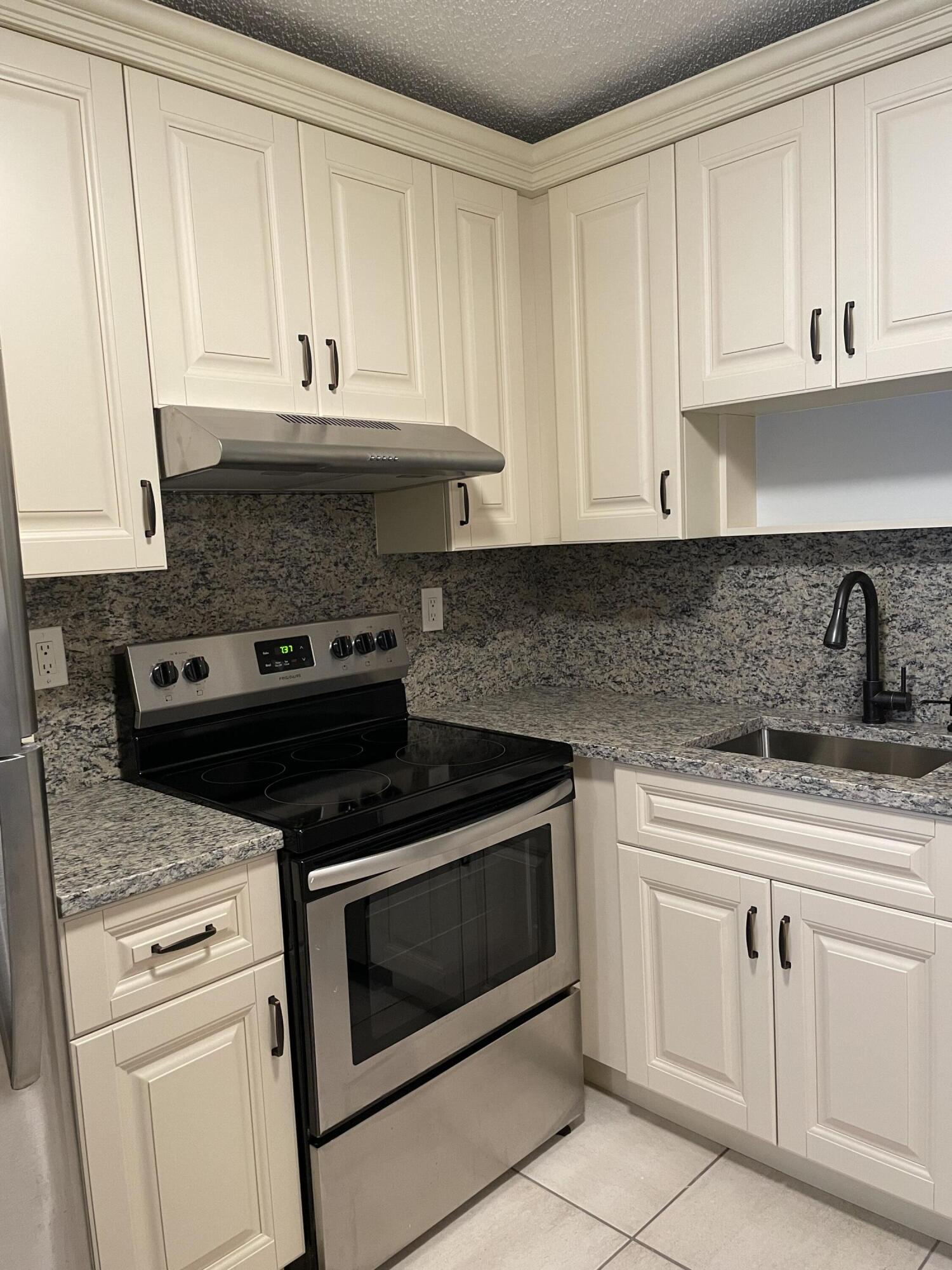9440 Southwest 8th Street, Unit 217 Boca Raton, FL 33428 - Photo 11 of 28 a kitchen with white cabinets and appliances
