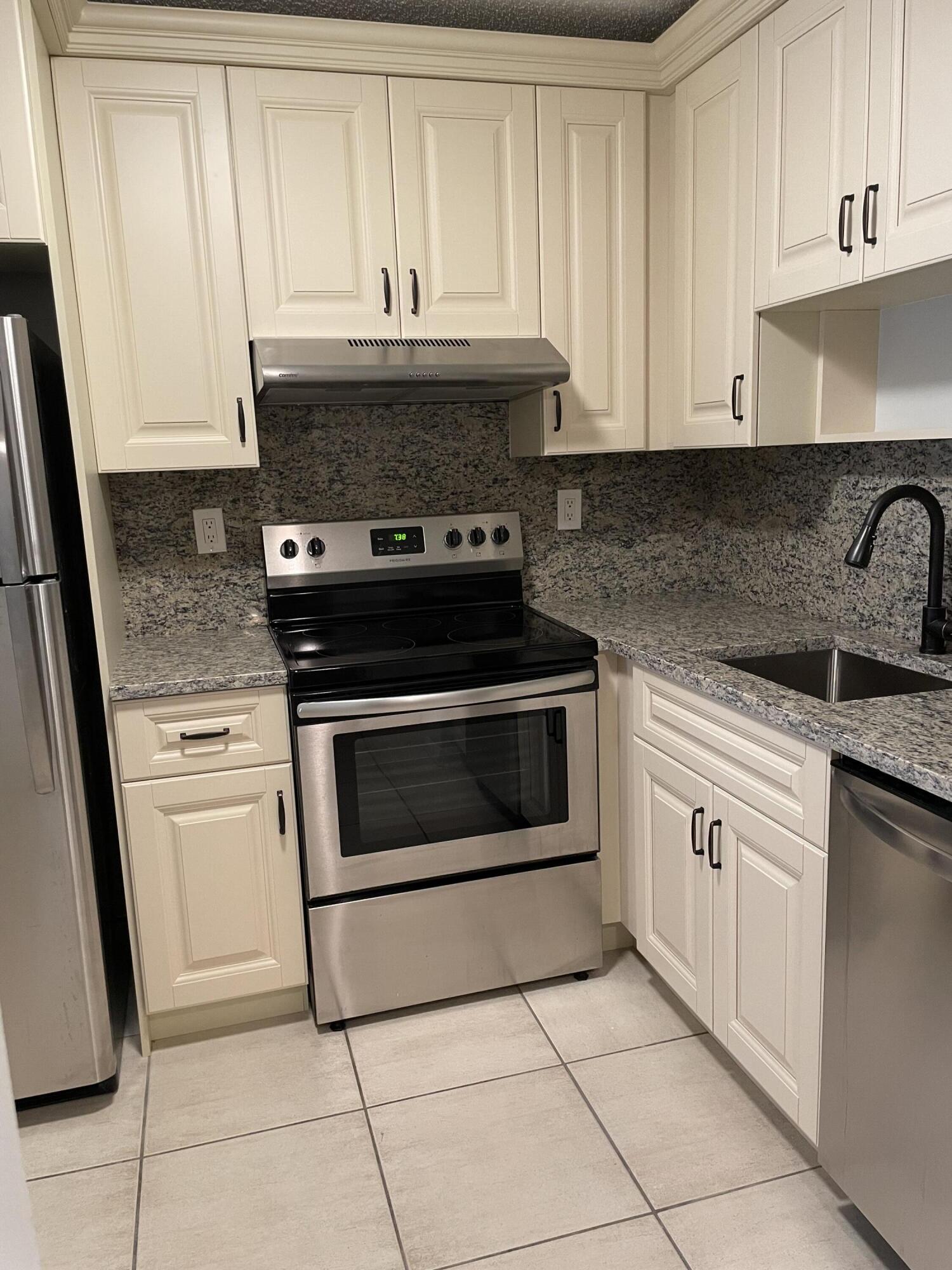 9440 Southwest 8th Street, Unit 217 Boca Raton, FL 33428 - Photo 12 of 28 a stove top oven sitting inside of a kitchen