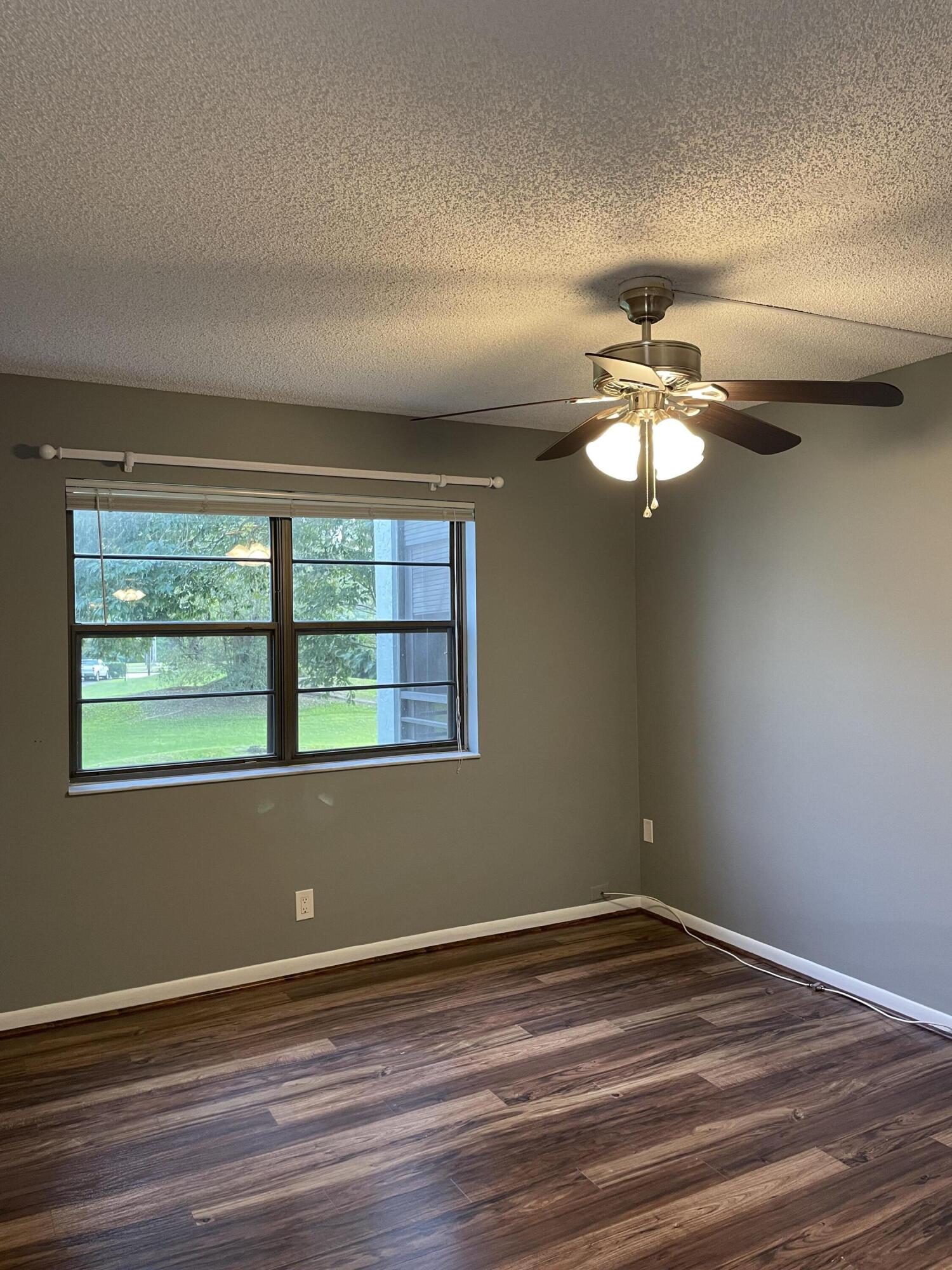9440 Southwest 8th Street, Unit 217 Boca Raton, FL 33428 - Photo 18 of 28 a view of an empty room with wooden floor and a window