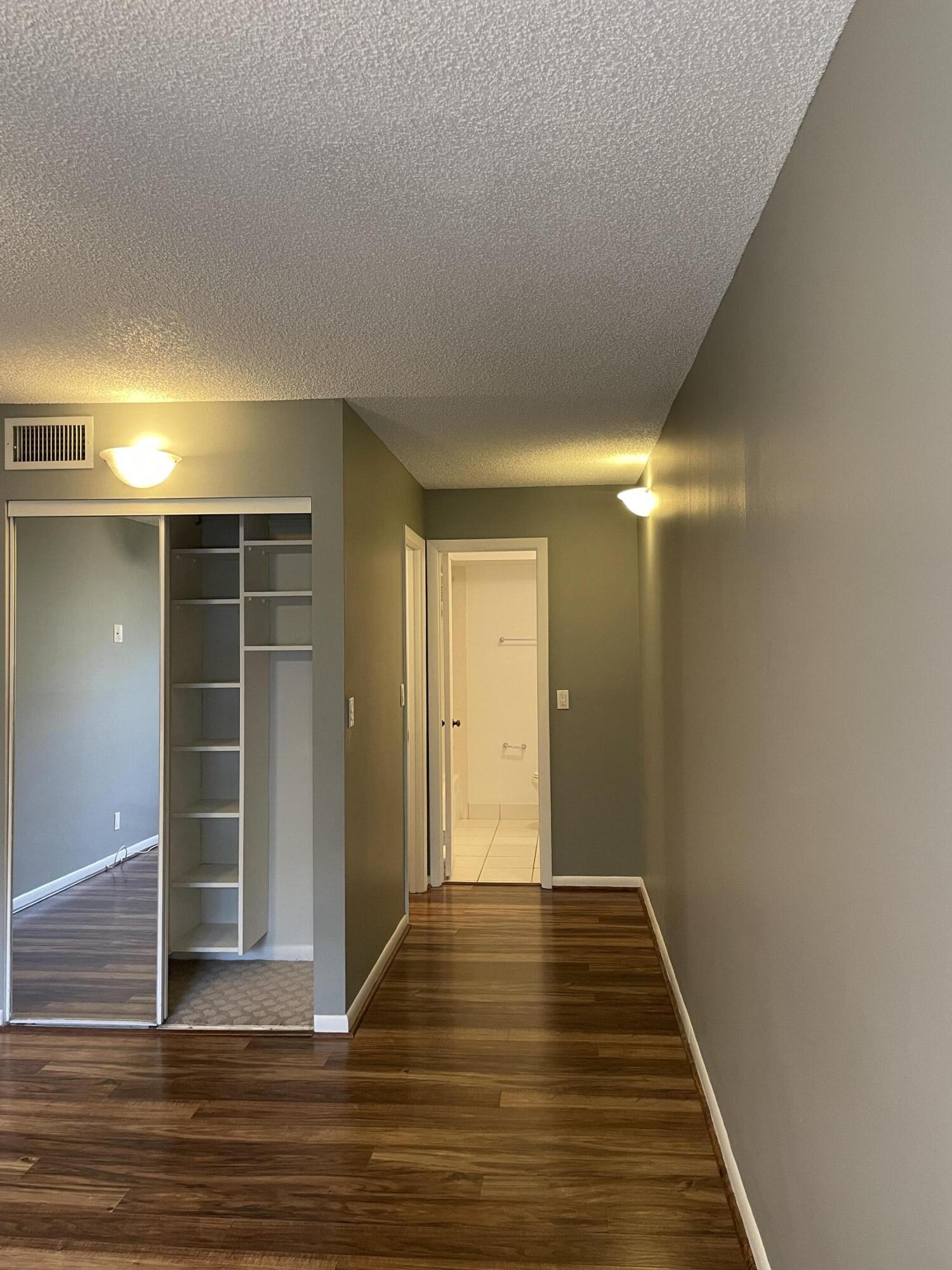 9440 Southwest 8th Street, Unit 217 Boca Raton, FL 33428 - Photo 20 of 28 a view of room with door and wooden floor