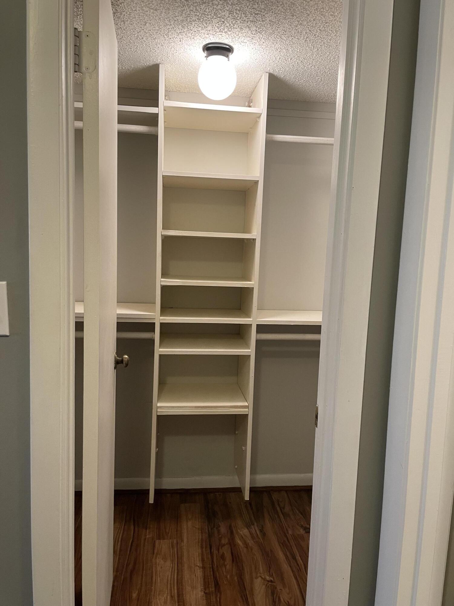 9440 Southwest 8th Street, Unit 217 Boca Raton, FL 33428 - Photo 22 of 28 a room with walk in closet and wooden floor