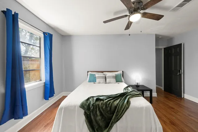 a bedroom with a bed window and a flat screen tv