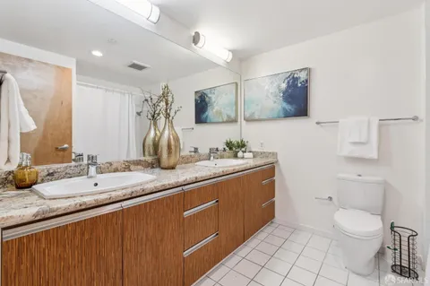 a bedroom with a bed a mirror and a large window