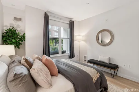 a bedroom with a bed and a potted plant