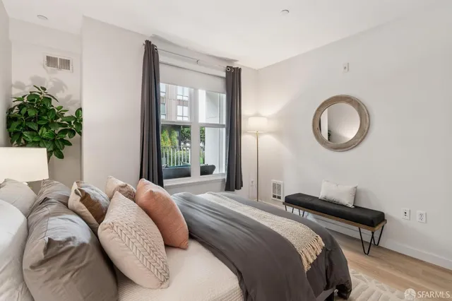 a bedroom with a bed and a potted plant