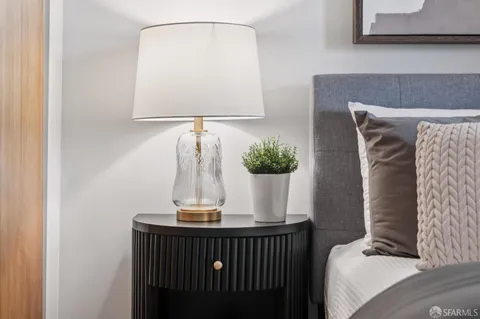 a bedroom with a large bed and a potted plant