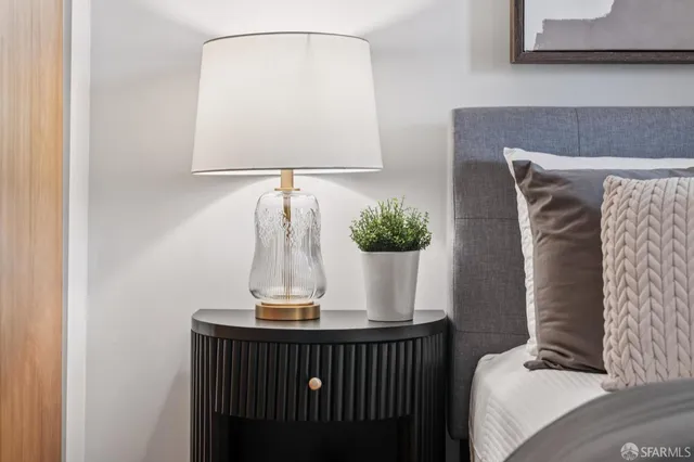 a bedroom with a large bed and a potted plant