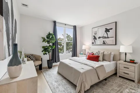 a spacious bedroom with a bed and a painting on the wall