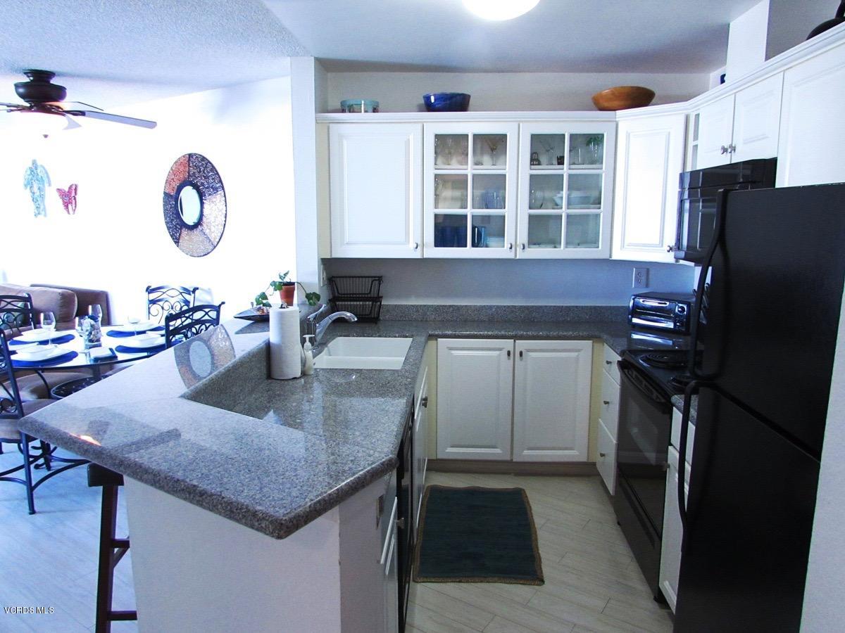 3101 Peninsula Road, Unit 312 Oxnard, CA 93035 - Photo 2 of 14 a kitchen with a table chairs and a refrigerator