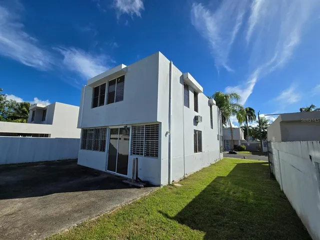 a view of a house with backyard and sitting area