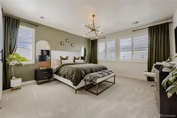 a spacious bedroom with a bed and a chandelier