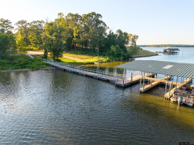an aerial view of a house with swimming pool and lake view