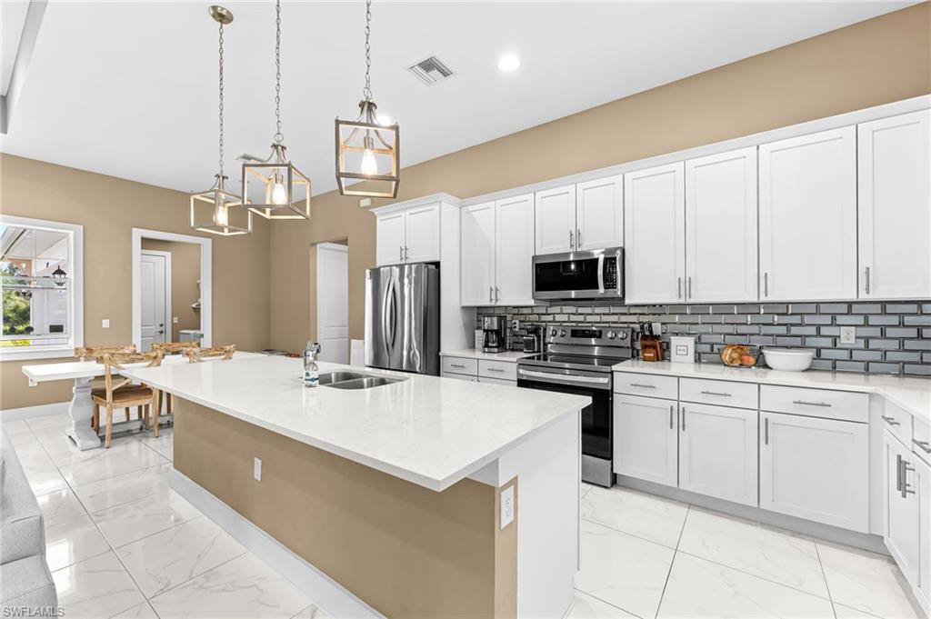 2793 72nd Avenue Northeast Naples, FL 34120 - Photo 13 of 50 a kitchen with appliances a sink and cabinets
