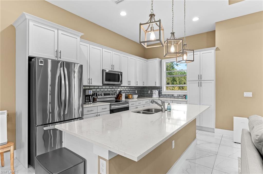 2793 72nd Avenue Northeast Naples, FL 34120 - Photo 14 of 50 a kitchen with stainless steel appliances a refrigerator sink and microwave