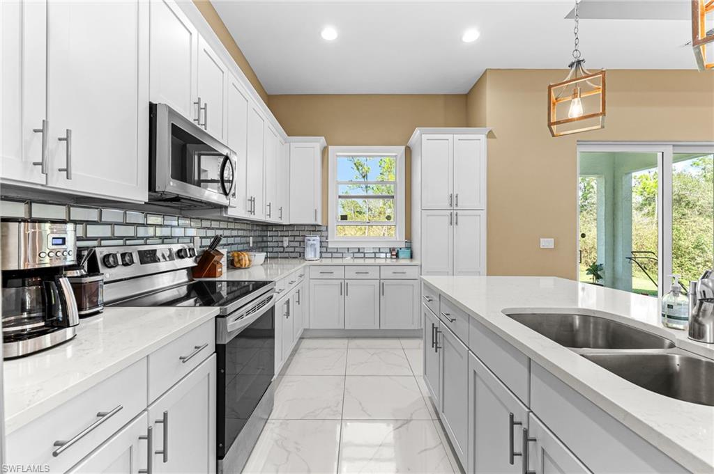 2793 72nd Avenue Northeast Naples, FL 34120 - Photo 16 of 50 a kitchen with stainless steel appliances granite countertop a sink and cabinets