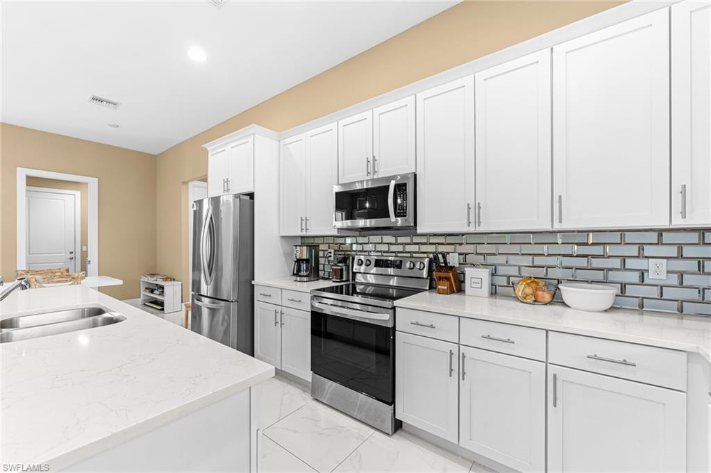 2793 72nd Avenue Northeast Naples, FL 34120 - Photo 18 of 50 a kitchen with appliances a sink and cabinets