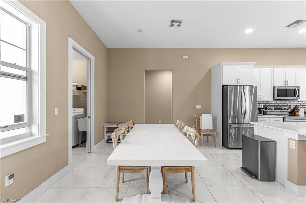 2793 72nd Avenue Northeast Naples, FL 34120 - Photo 20 of 50 a large kitchen with a table chairs refrigerator and microwave