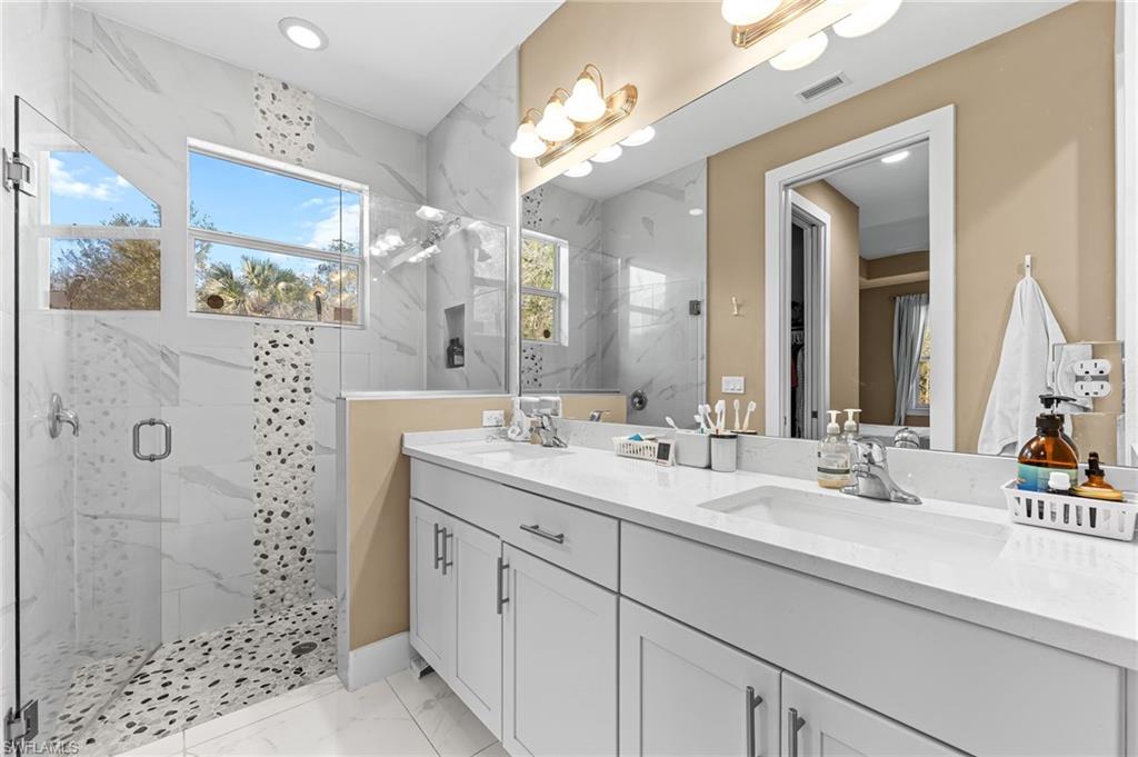 2793 72nd Avenue Northeast Naples, FL 34120 - Photo 29 of 50 a bathroom with a double vanity sink mirror and shower
